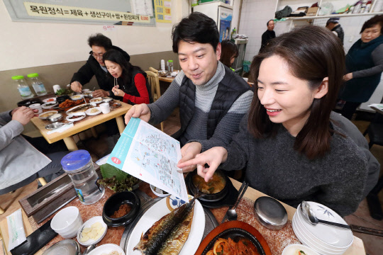 KT 직원들이 8일 충정로 2가 식당 골목에서 '아현 100대 맛집' 지도를 보고 있다. KT 제공